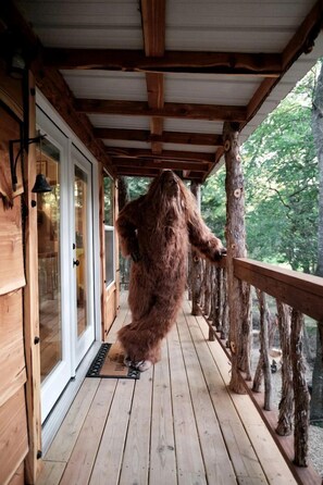 A wooden deck with a glass door and a wooden railing.