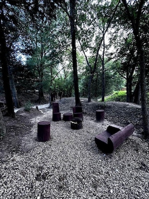 A forested area with wooden benches and a gravel path.