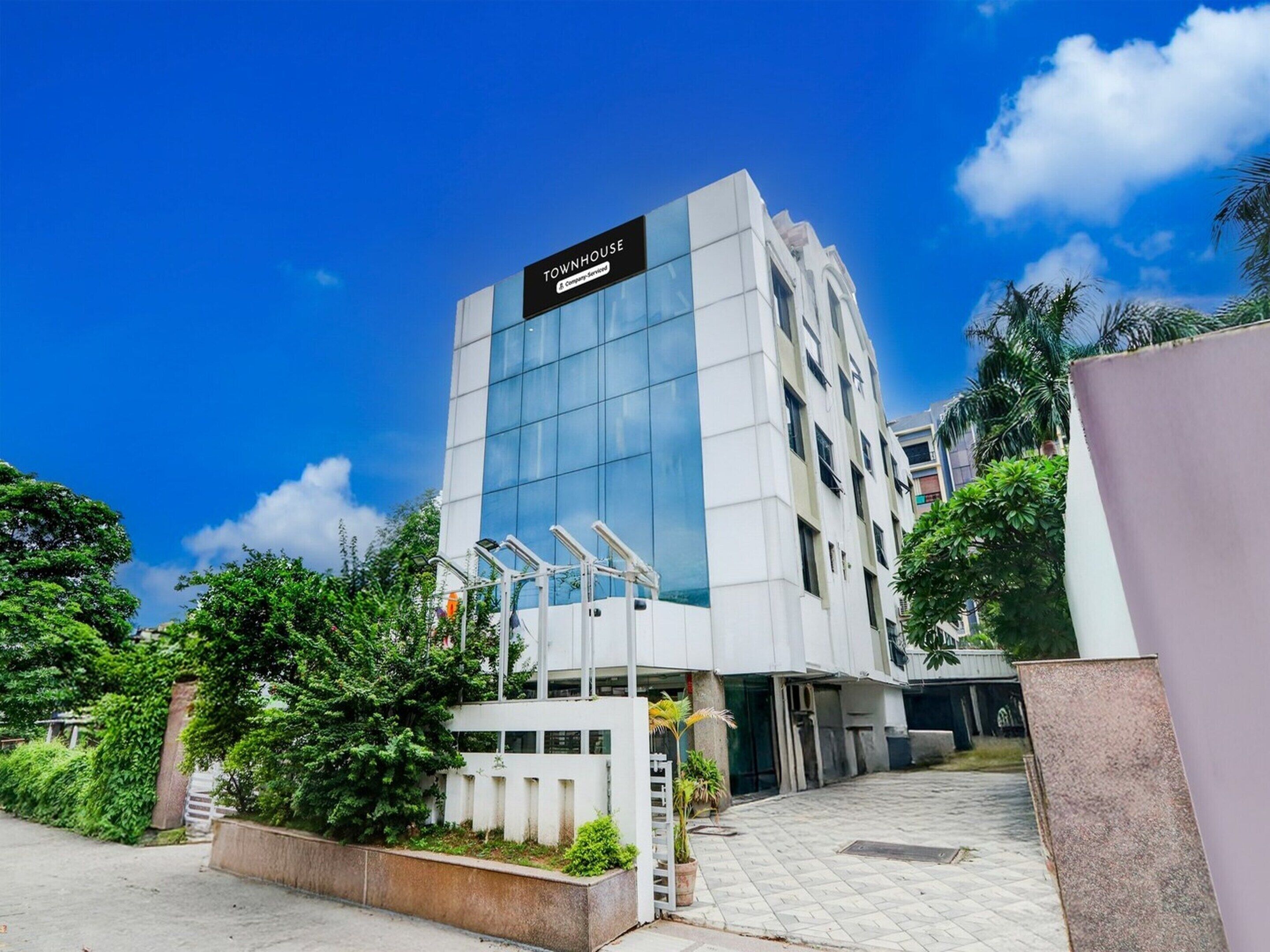 A modern building with a sign reading 'TOWNHOUSE' and a gated entrance.
