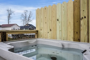 A hot tub with a wooden fence and a view of houses in the background. - Comfortable Retreat with Hot-Tub in Sevierville, Tennessee (Sevierville)