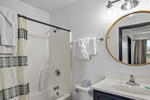 A bathroom with a shower, a sink, a toilet, and a mirror. - Comfortable Retreat with Hot-Tub in Sevierville, Tennessee (Sevierville)