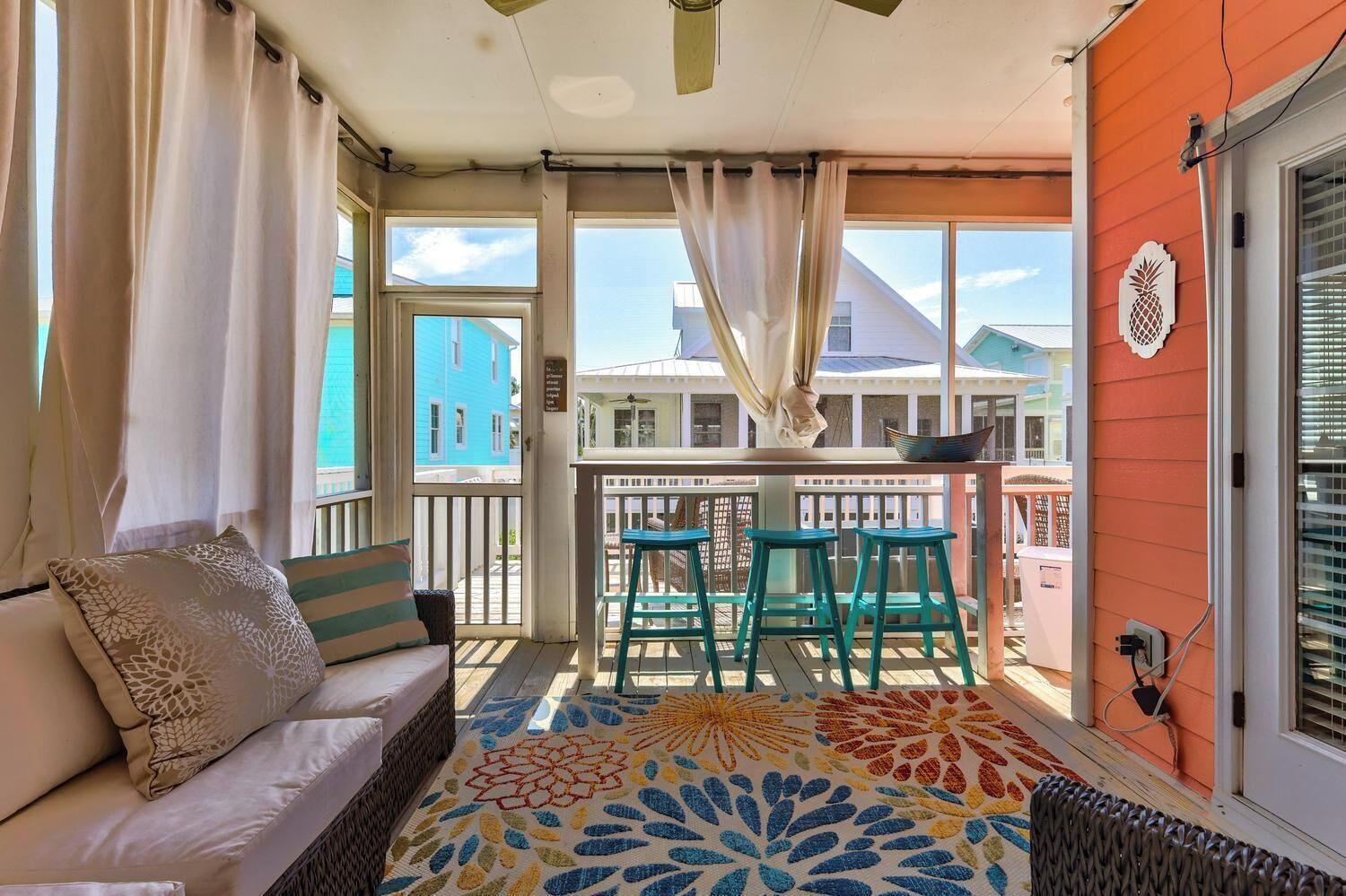 Ein Balkon mit einer Couch, Stühlen und einem gemusterten Teppich.