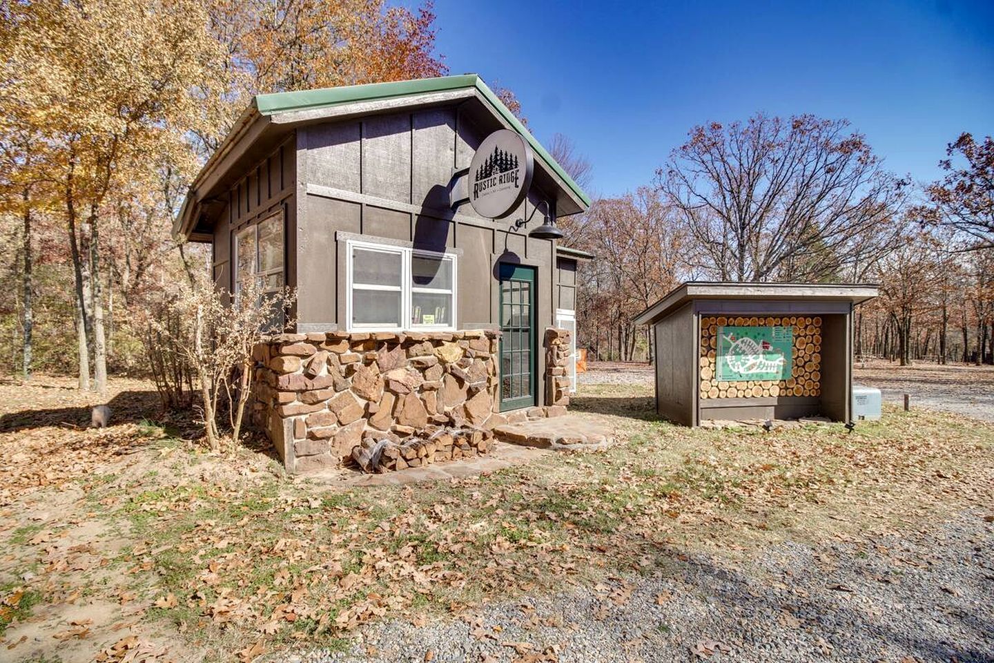 A rustic lodge with a stone foundation, a wooden exterior, and a signboard.