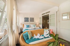A hotel room with two beds, a sofa, and a large window with curtains. - Dhamanadi Boutique Resort (Megamendung)