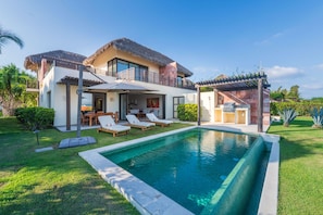 A modern house with a swimming pool, a patio with lounge chairs, and a thatched roof. - Villa Turquesa in Punta Mita (Punta de Mita)