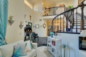 A spacious living area with a staircase, a white sofa, decorative wall sconces, and a chandelier. - Hot Tub! Extended Escape 9 Mi to Oceanside Beach (Oceanside)