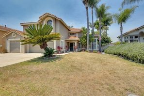 A two-story house with a garage, a front yard with a palm tree, and a well-maintained lawn. - Hot Tub! Extended Escape 9 Mi to Oceanside Beach (Oceanside)