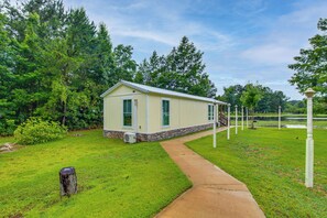 A single-story building with a sloped roof, a stone foundation, and a small porch. - Waterfront Couples Retreat w/ Views in Andalusia! (Andalusia)