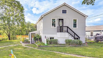 A two-story house with a front porch, a staircase, and a fenced yard.