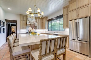 A kitchen with a large island, wooden chairs, a chandelier, and stainless steel appliances. - Stunning Views! Luxurious & Secluded Glen Rose Gem (Glen Rose)