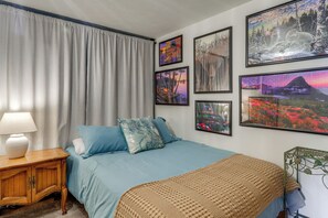 A bedroom with a bed, a nightstand, a lamp, and four framed pictures on the wall. - Private Dock, Deck & Yard: Luxe Sacheen Lake Home (Newport)