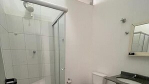 A bathroom with a glass shower enclosure, a toilet, and a sink with a mirror. - Vista Bela Hotel Pindamonhangaba  (Pindamonhangaba)