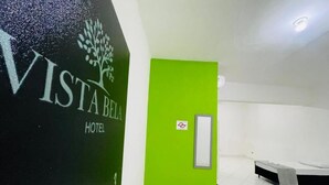 A hotel room with a green door, a bed, and a wall-mounted control panel. - Vista Bela Hotel Pindamonhangaba  (Pindamonhangaba)