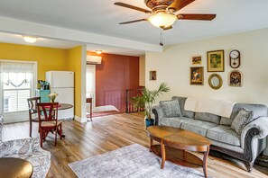 A living room with a sofa, coffee table, and dining area with chairs and a table.