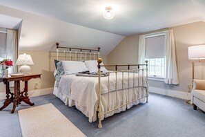 A bedroom with a four-poster bed, a bedside table with a lamp, a window with curtains, and a view of the outdoors. - Iconic Finger Lakes Home Near Taughannock Falls (Trumansburg)