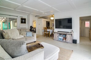 A living room with a sofa, TV, and dining area. - Access to Centerville's Resident Beaches! Cozy Gem (Centerville)