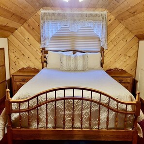 Ein hölzernes Bett mit Baldachin, zwei Nachttische und ein dekoratives Kopfende.