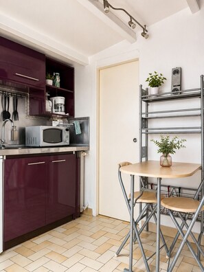 A compact kitchen with a microwave, a coffee maker, and a potted plant on a shelf. - Cozy Cottage with Veranda in Les Sables d'Olonne (Les Sables-d´Olonne)