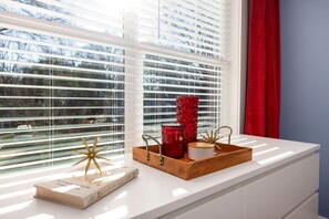 A room with a large window, a wooden tray with decorative items, and a book on the windowsill. - Luminous Urban Vacation Rental Haven near Catawba River in North Carolina (Charlotte)