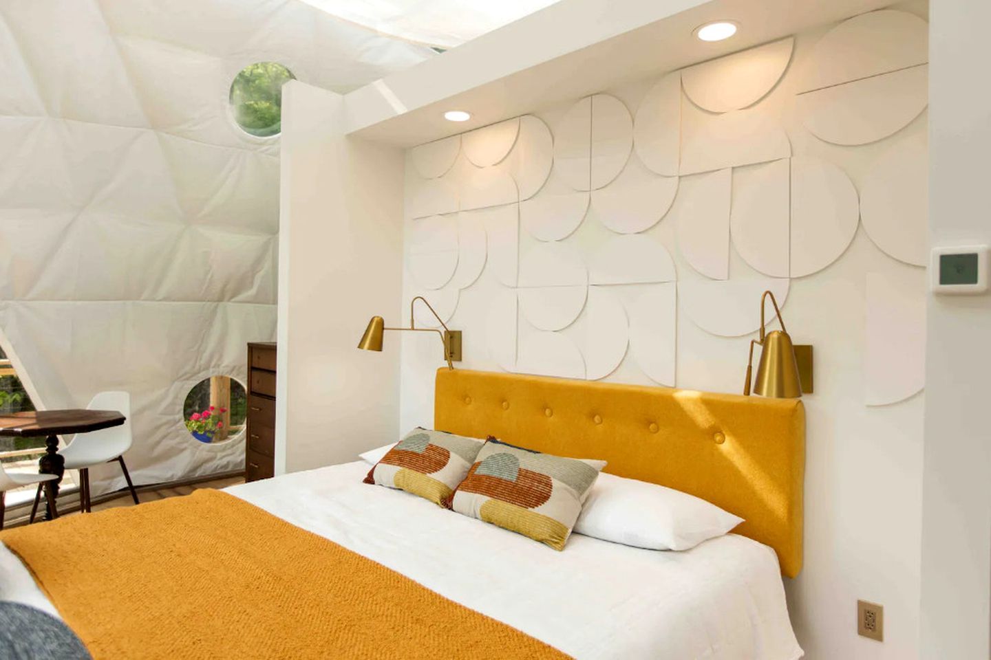 A hotel room with a bed, a desk, and a chair.