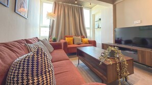 Ein modernes Wohnzimmer mit einer Couch, einem Couchtisch und einem Fernseher.