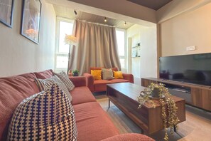 A modern living room with a sofa, a coffee table, and a TV. - Nicosia 2BR Apt with AC & Washer (Metehan)