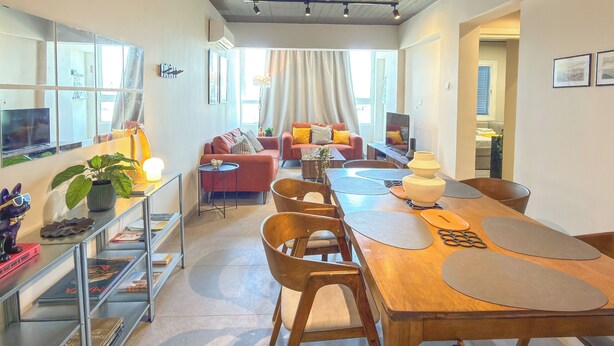 Ein modernes Interieur mit Essbereich, Sofas und einem großen Fenster.