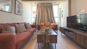 Ein modernes Wohnzimmer mit Sofa, Couchtisch und Fernsehschrank.