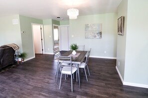 A dining area with a table and chairs, a chandelier, and artwork on the walls.