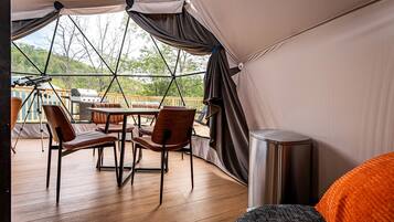Un espacio al aire libre con carpas, una mesa, sillas, una parrilla y un telescopio.