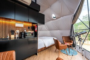 A tented accommodation with a kitchenette, a bed, a telescope, and a seating area. - Geodesic Dome Retreat with Hot Tub & Fire Pit in Bluefield, West Virginia (Blueflield)