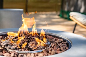 A fire pit with flames, surrounded by a metal rim.