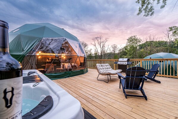 A tented outdoor area with a hot tub, deck chairs, and a grill. - Geodesic Dome Retreat with Hot Tub & Fire Pit in Bluefield, West Virginia (Blueflield)