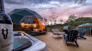 Une terrasse dotée d’un jacuzzi, d’un espace salon extérieur et d’une zone abritée par une tente.