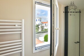 Ein Zimmer mit Fenster, Heizkörper und einer Tür mit einem Logo.