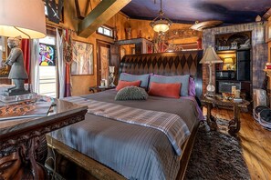 A bedroom with a large bed, wooden headboard, and a chandelier. - Romantic Open-Concept Couples Suite with Private Jacuzzi & Balcony Views in Bacliff, Texas (Bacliff)