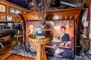 A room with a round wooden table, a vintage-style sofa, and a decorative wall with framed pictures. - Romantic Open-Concept Couples Suite with Private Jacuzzi & Balcony Views in Bacliff, Texas (Bacliff)