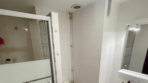 A bathroom with a shower, toilet, sink, and mirror. - Charming 1-bedroom Apartment in the Heart of Madrid (Madrid)