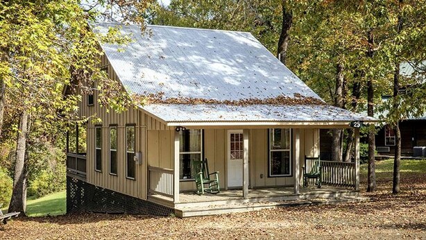 A small, single-story cabin with a porch, surrounded by trees. - Peaceful Waterfront Cabin with Private Pond Near Zwolle, Louisiana (Zwolle)