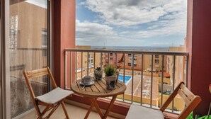 A balcony with a view of the sea, a table with chairs, and potted plants. - Erma Sun & Pool - Apartment in Candelaria (Candelaria)