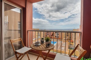 A balcony with a view of the sea, a table with chairs, and potted plants. - Erma Sun & Pool - Apartment in Candelaria (Candelaria)
