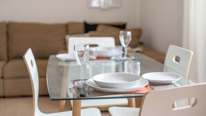 A dining table set with plates, glasses, and a wine glass. - Erma Sun & Pool - Apartment in Candelaria (Candelaria)