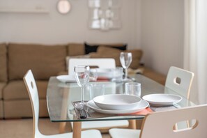 A dining table set with plates, glasses, and a wine glass. - Erma Sun & Pool - Apartment in Candelaria (Candelaria)