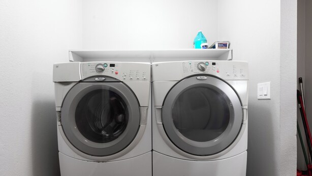 A front-loading washer and dryer unit with control panels and a detergent dispenser on top. - Group Home Near Stadium | Sleeps 14+ (El Mirage)