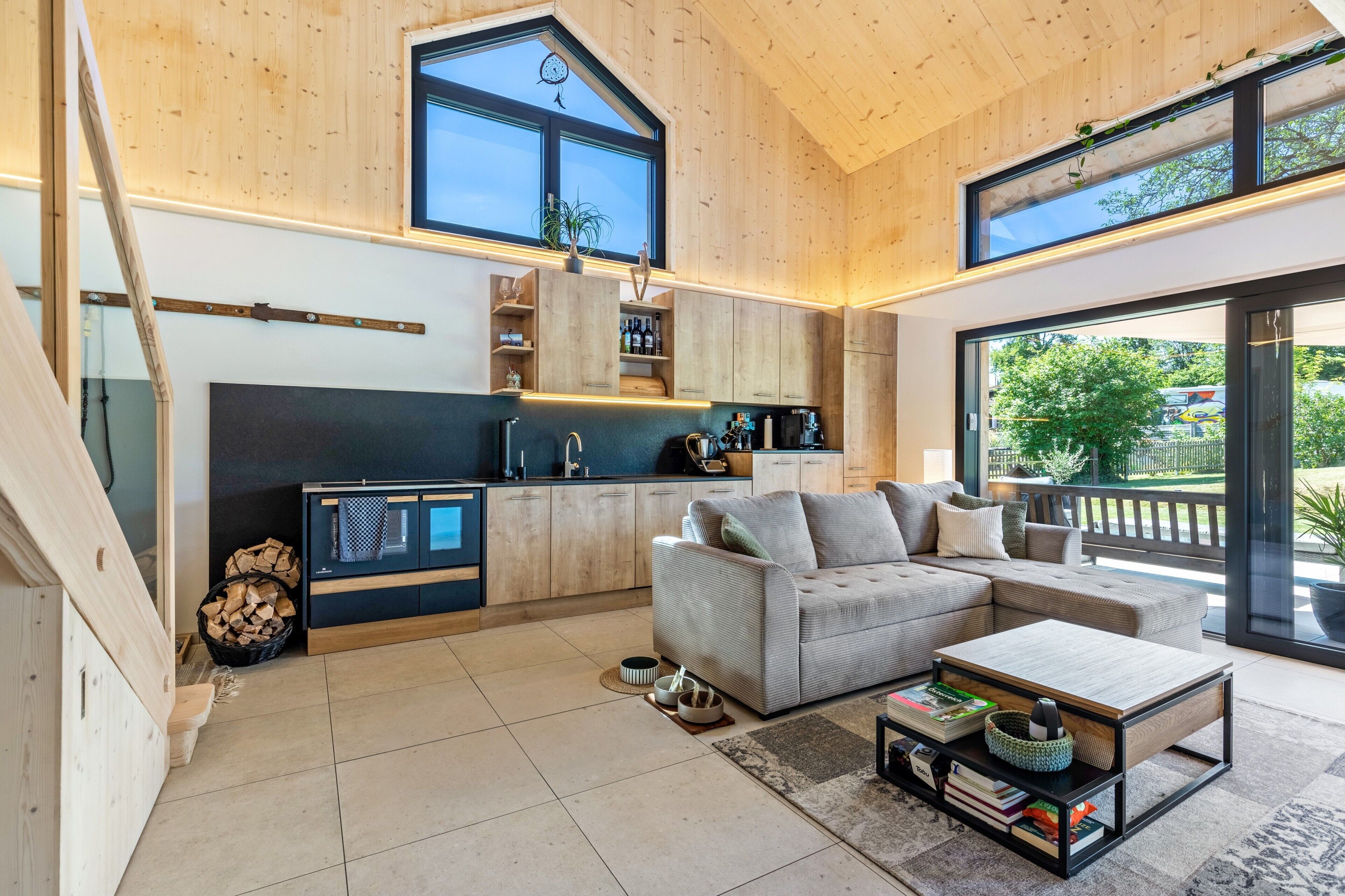 A modern interior with a kitchen, seating area, and large windows.