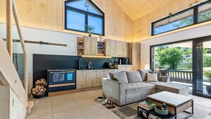 Un interior moderno con cocina, zona de estar y grandes ventanales.