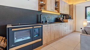 Una cocina moderna con horno empotrado, cafetera y armarios de madera.