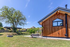 Une maison en bois avec une grande fenêtre et une cheminée.