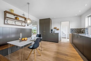 Una cocina moderna con comedor, suelo de madera y un mueble grande.