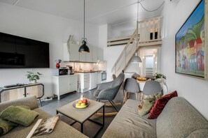 Ein modernes Wohnzimmer mit einer Couch, einem Couchtisch und einem Essbereich mit Tisch und Stühlen.